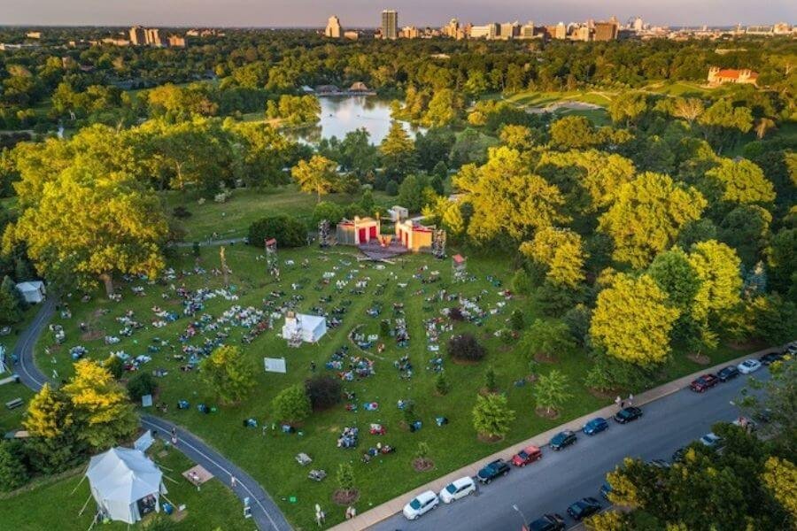 A captivating high-angle view of Forest Park, beautifully illuminated under the twilight sky, perfectly staged for an immersive experience of Shakespeare in the Park.